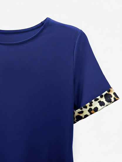 Blue - Woman wearing a short-sleeve shift mini dress with leopard print trim on the sleeves and hem, holding a small handbag