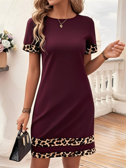 Burgundy - Woman wearing a short-sleeve shift mini dress with leopard print trim on the sleeves and hem, holding a small handbag