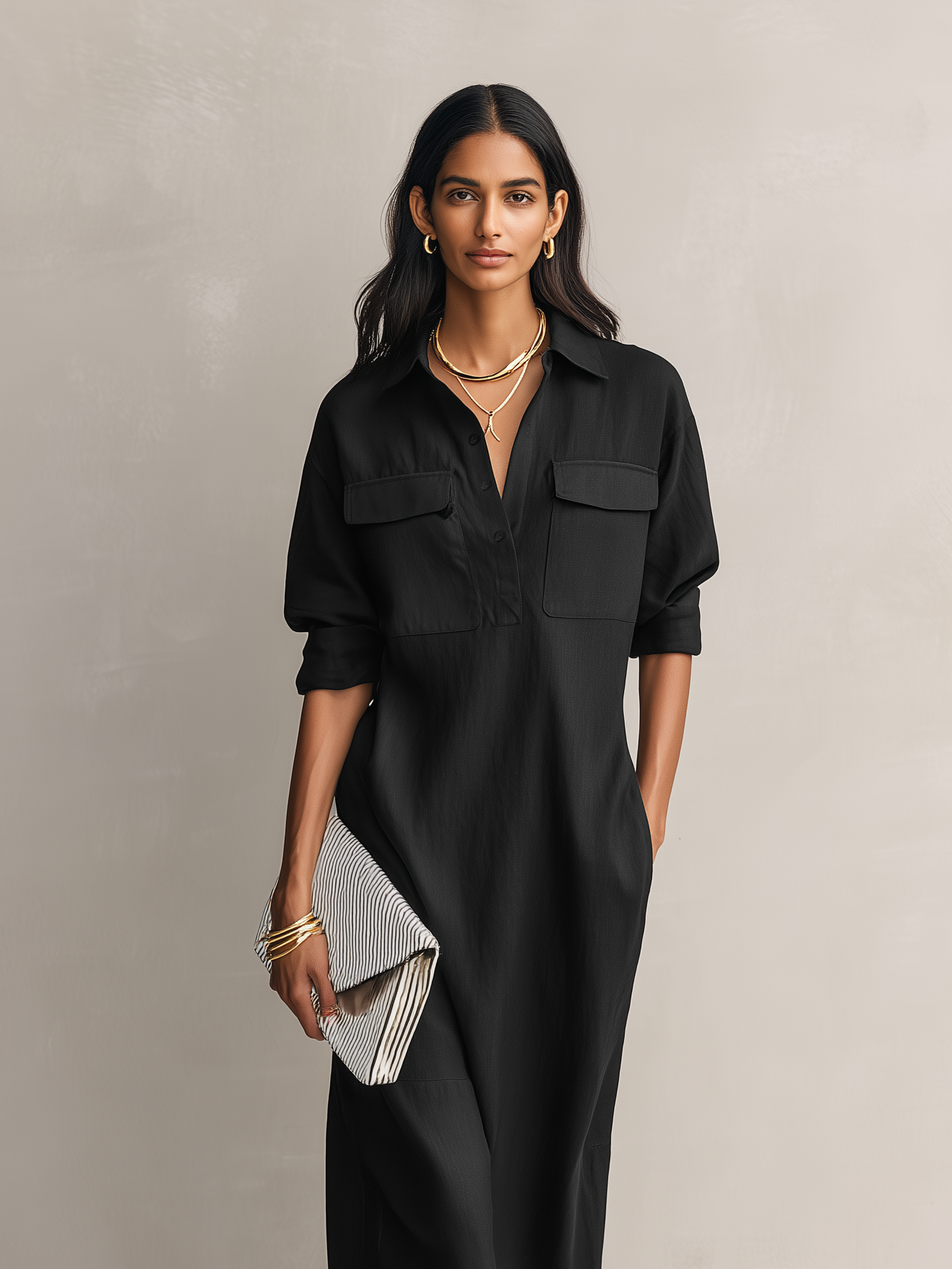 Black - Model wearing a relaxed fit, long-sleeve midi shirtdress with a collar, chest pockets, and side pockets against a neutral background.
