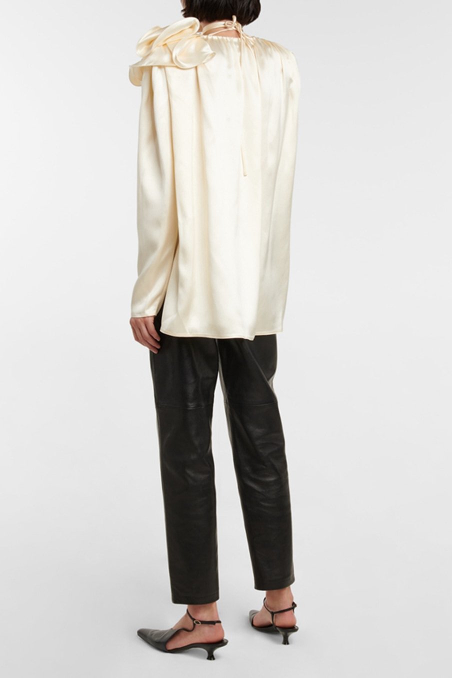 Woman in cream silk satin blouse with ruffle detail
