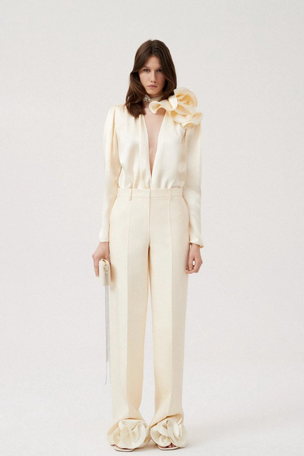 Woman in cream silk satin blouse with ruffle detail