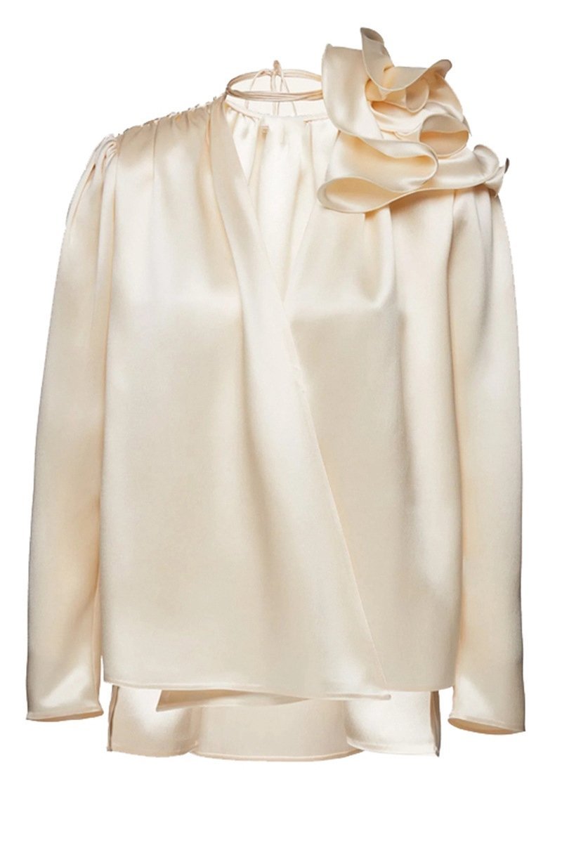 Woman in cream silk satin blouse with ruffle detail