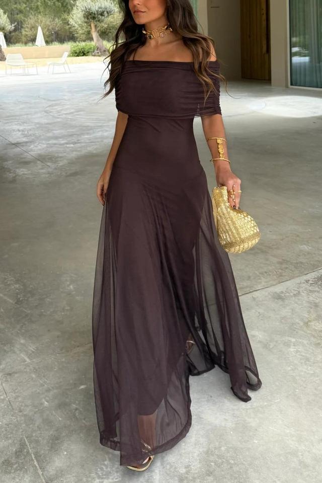 Brown - A woman wearing an elegant off-the-shoulder floor-length maxi dress featuring a ruched bodice and a sheer mesh overlay, styled with gold accessories.