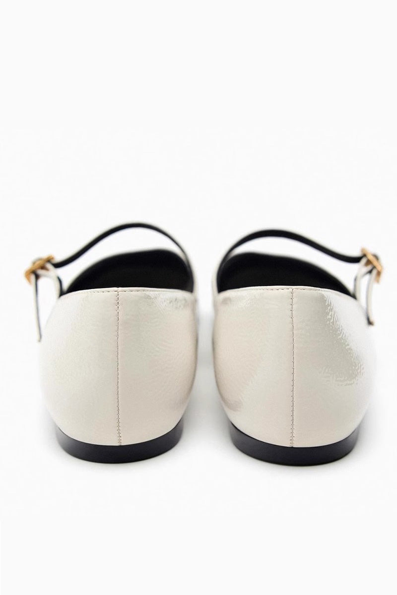 Off-White - Top-down view of women's black glossy patent Mary Jane flats featuring a thin instep strap and small metallic buckle.