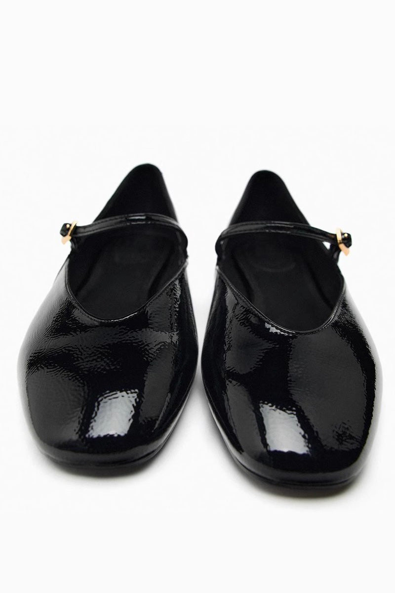 Top-down view of women's black glossy patent Mary Jane flats featuring a thin instep strap and small metallic buckle.