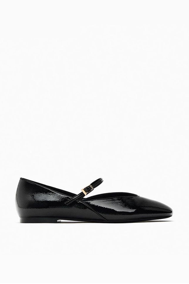 Black - Top-down view of women's black glossy patent Mary Jane flats featuring a thin instep strap and small metallic buckle.