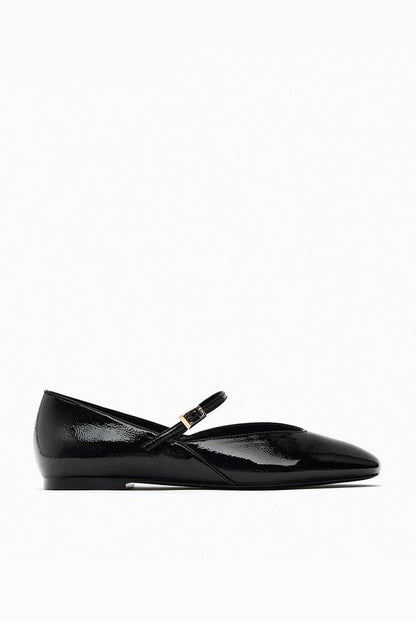 Black - Top-down view of women's black glossy patent Mary Jane flats featuring a thin instep strap and small metallic buckle.