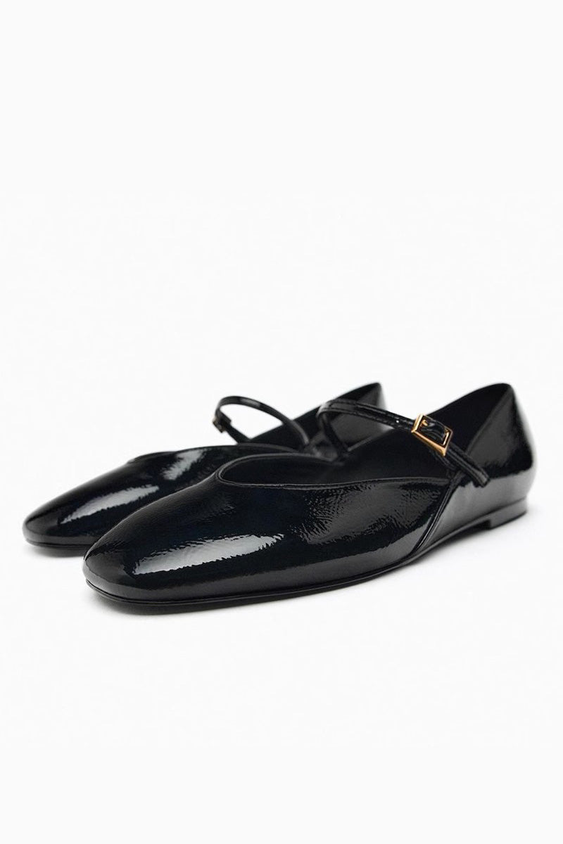 Black - Top-down view of women's black glossy patent Mary Jane flats featuring a thin instep strap and small metallic buckle.