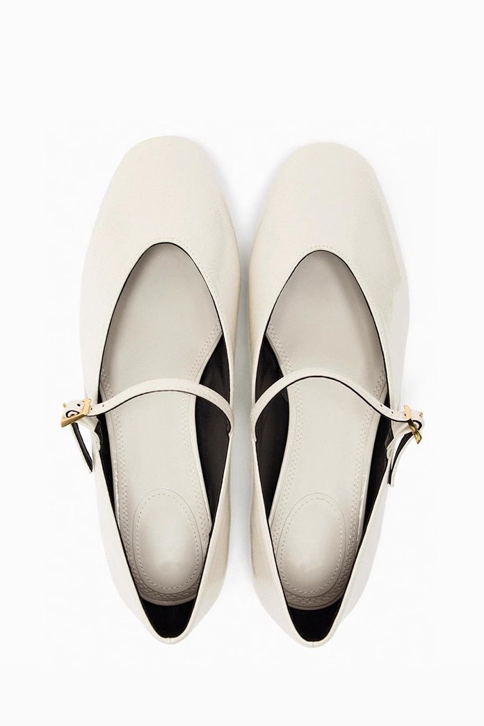 Black - Top-down view of women's black glossy patent Mary Jane flats featuring a thin instep strap and small metallic buckle.