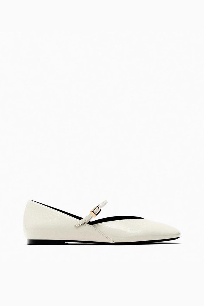 Off-White - Top-down view of women's black glossy patent Mary Jane flats featuring a thin instep strap and small metallic buckle.