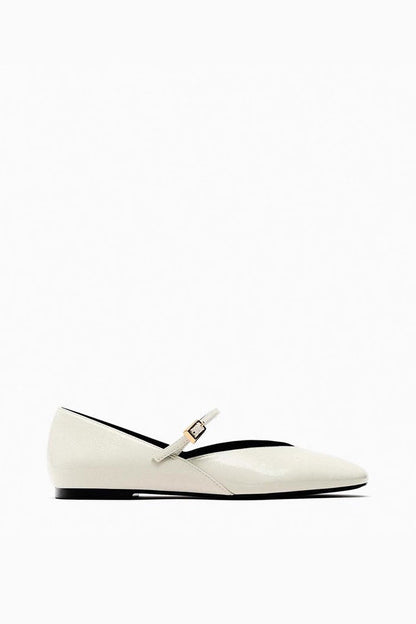 Off-White - Top-down view of women's black glossy patent Mary Jane flats featuring a thin instep strap and small metallic buckle.