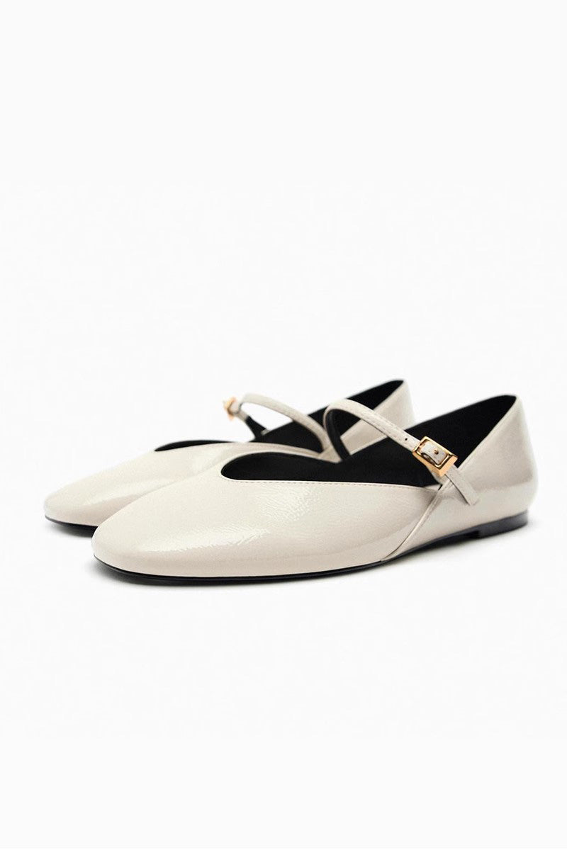 Off-White - Top-down view of women's black glossy patent Mary Jane flats featuring a thin instep strap and small metallic buckle.