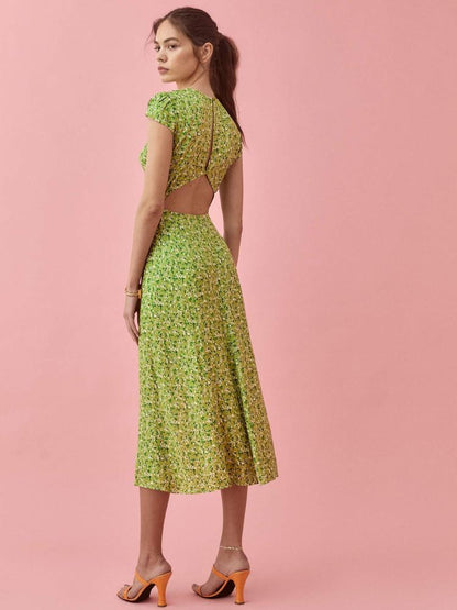 Woman in green floral midi dress with thigh-high slit