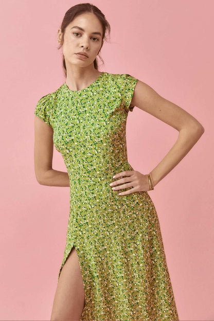 Woman in green floral midi dress with thigh-high slit