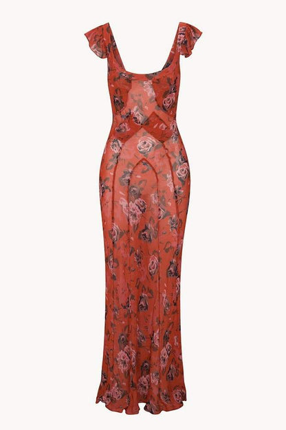 Red - A woman wearing a rust-colored, rose-printed chiffon maxi dress with ruffle cap sleeves and a scoop neckline, posing against a neutral textured backdrop.