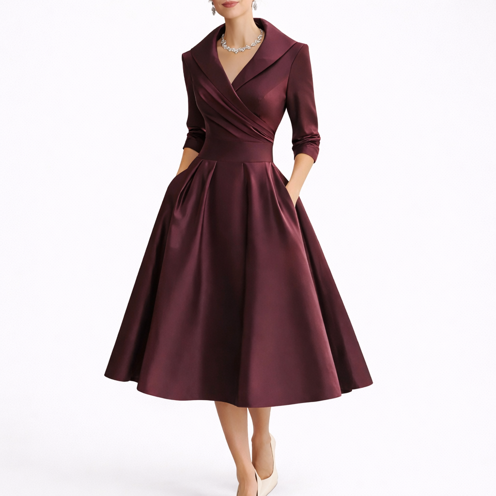 Red - Woman wearing a structured A-line midi dress with a wide portrait collar, wrap bodice, 3/4 sleeves, and a full pleated skirt with pockets.