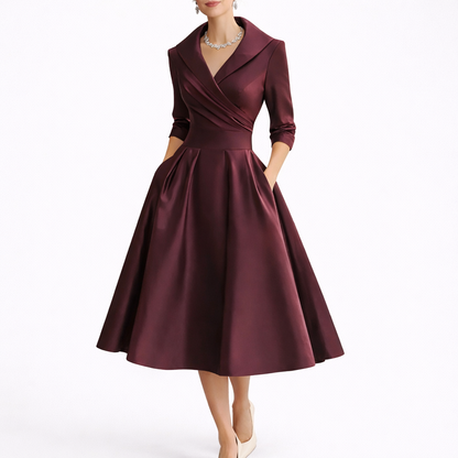 Red - Woman wearing a structured A-line midi dress with a wide portrait collar, wrap bodice, 3/4 sleeves, and a full pleated skirt with pockets.
