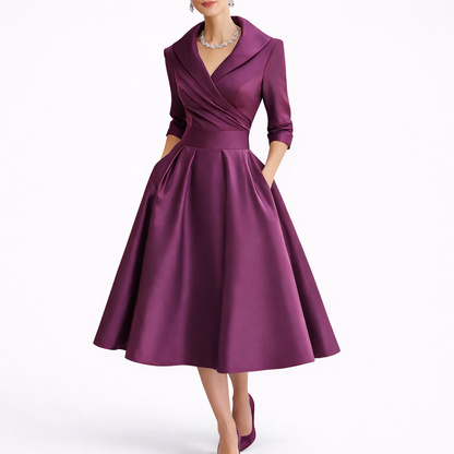 Purple - Woman wearing a structured A-line midi dress with a wide portrait collar, wrap bodice, 3/4 sleeves, and a full pleated skirt with pockets.
