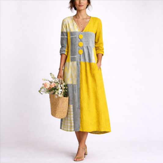 XL - A woman wearing a textured patchwork V-neck midaxi dress with 3/4 sleeves, large front buttons, and side pockets, holding a woven basket with flowers.