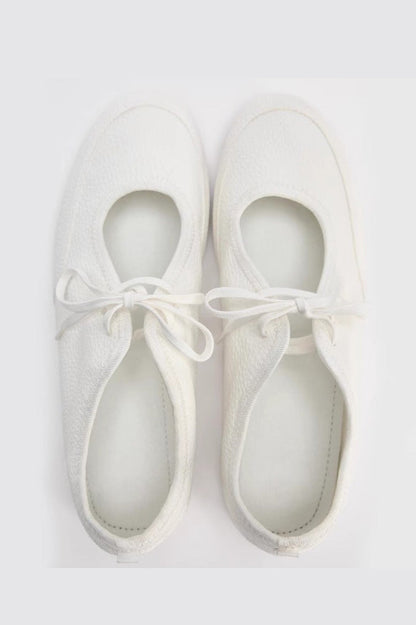 Women's white textured faux leather ballet flats with a delicate tie-front detail, viewed from above.