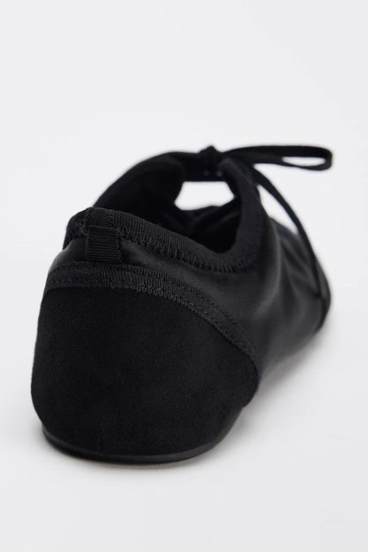 Black - Women's white textured faux leather ballet flats with a delicate tie-front detail, viewed from above.