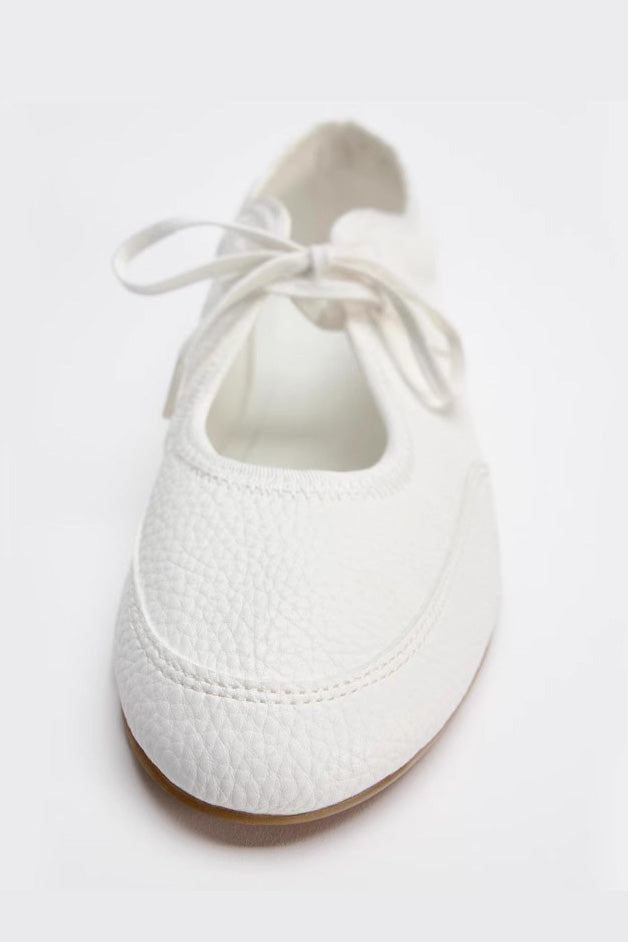 White - Women's white textured faux leather ballet flats with a delicate tie-front detail, viewed from above.