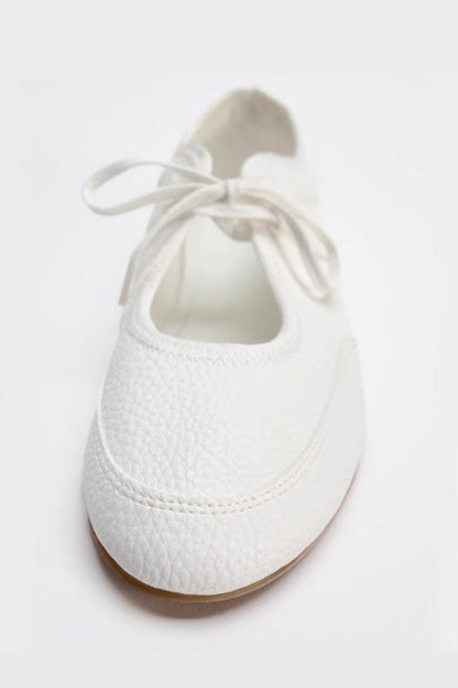 White - Women's white textured faux leather ballet flats with a delicate tie-front detail, viewed from above.