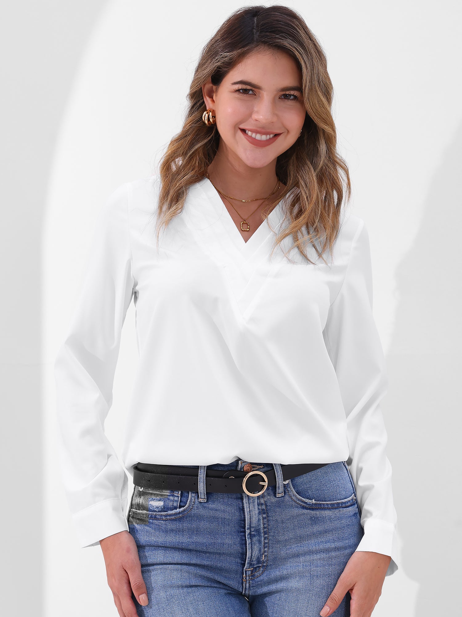 Pink - Women's long-sleeve blouse featuring a distinctive pleated V-neckline and buttoned cuffs, styled tucked into blue denim jeans.