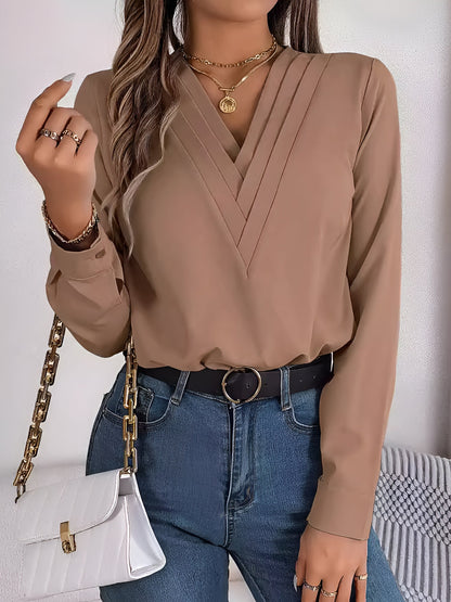 Pink - Women's long-sleeve blouse featuring a distinctive pleated V-neckline and buttoned cuffs, styled tucked into blue denim jeans.