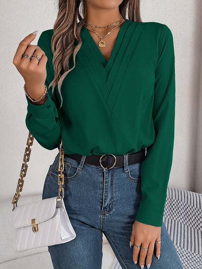 Burgundy - Women's long-sleeve blouse featuring a distinctive pleated V-neckline and buttoned cuffs, styled tucked into blue denim jeans.
