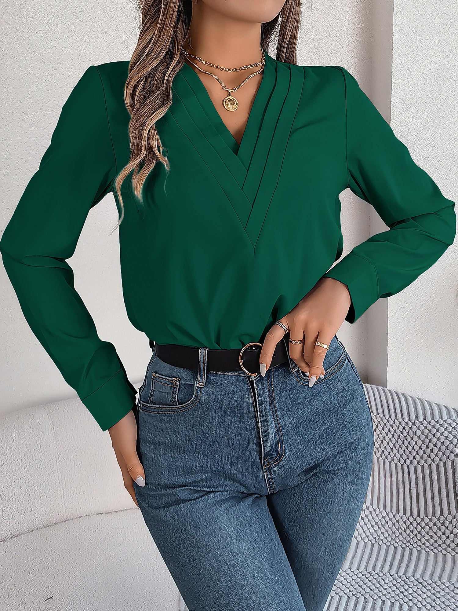 Burgundy - Women's long-sleeve blouse featuring a distinctive pleated V-neckline and buttoned cuffs, styled tucked into blue denim jeans.