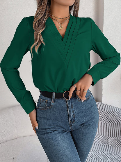 Burgundy - Women's long-sleeve blouse featuring a distinctive pleated V-neckline and buttoned cuffs, styled tucked into blue denim jeans.