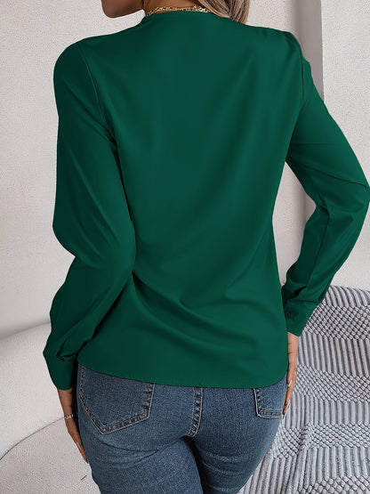 Burgundy - Women's long-sleeve blouse featuring a distinctive pleated V-neckline and buttoned cuffs, styled tucked into blue denim jeans.