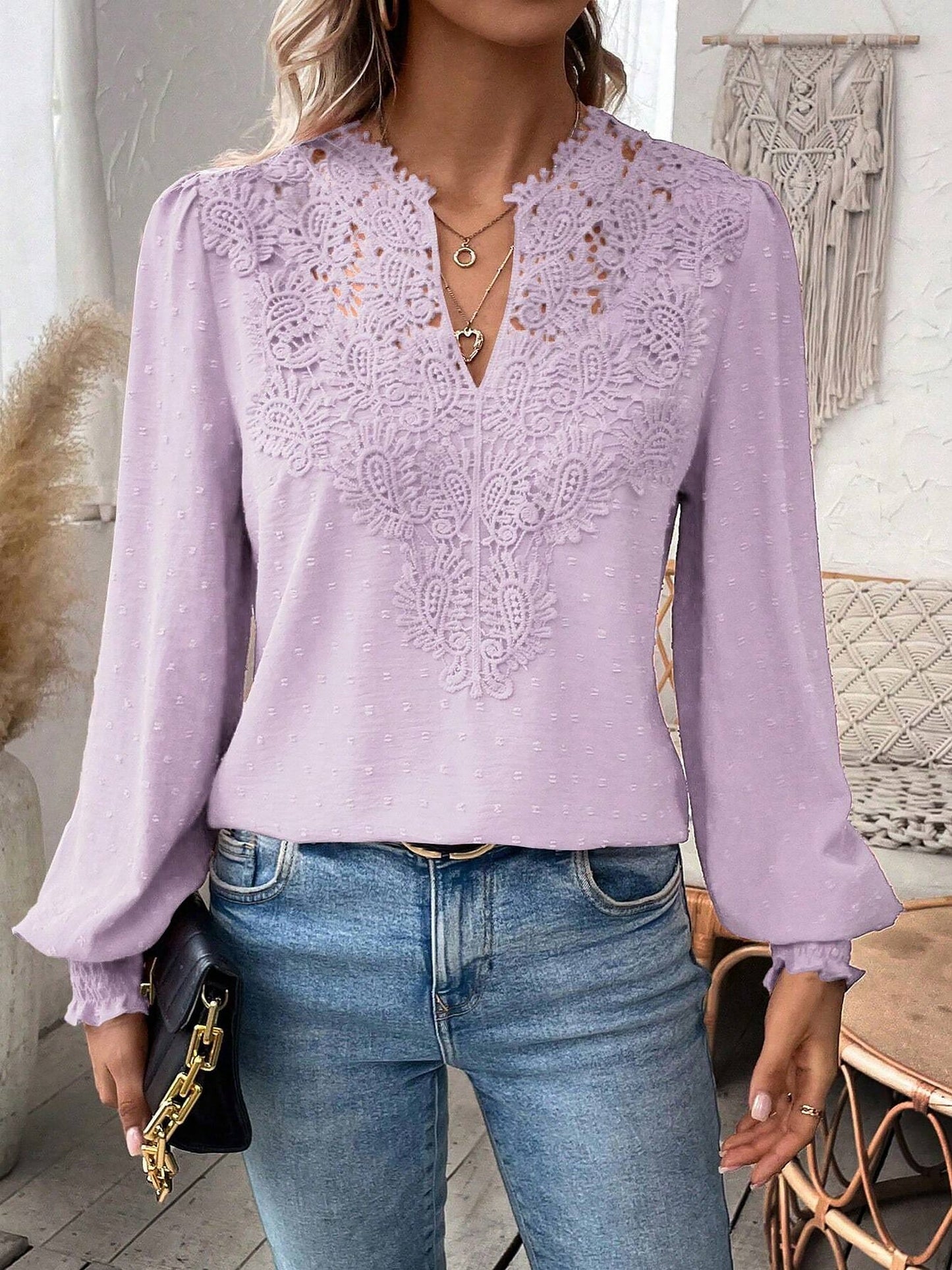 Lavender - Women's dusty rose long-sleeve blouse featuring a lace V-neckline, textured Swiss dot fabric, and smocked cuffs, styled with blue jeans.