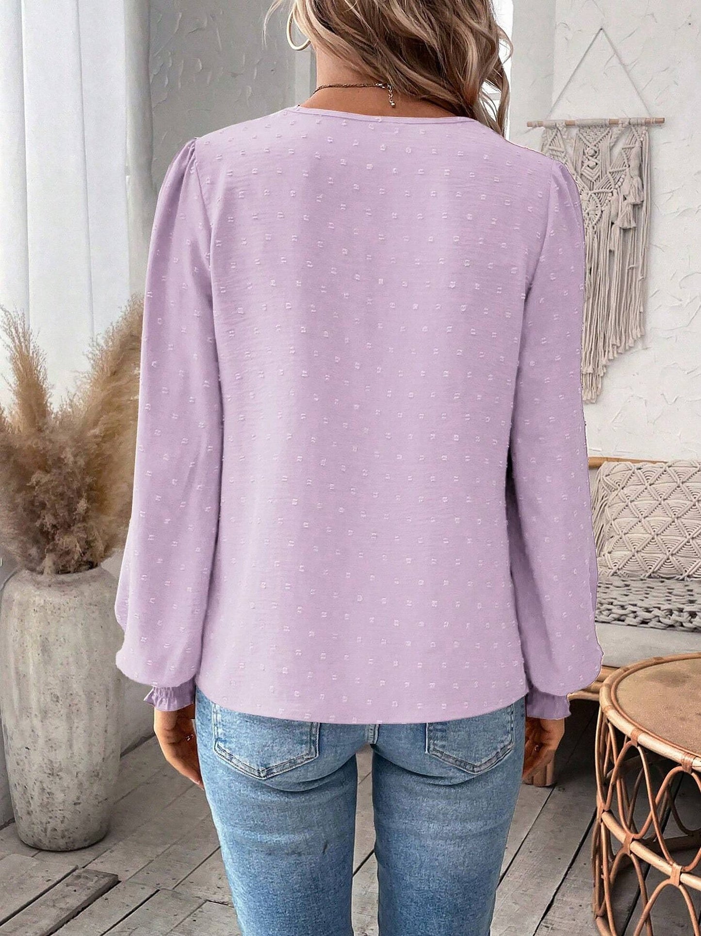 Lavender - Women's dusty rose long-sleeve blouse featuring a lace V-neckline, textured Swiss dot fabric, and smocked cuffs, styled with blue jeans.