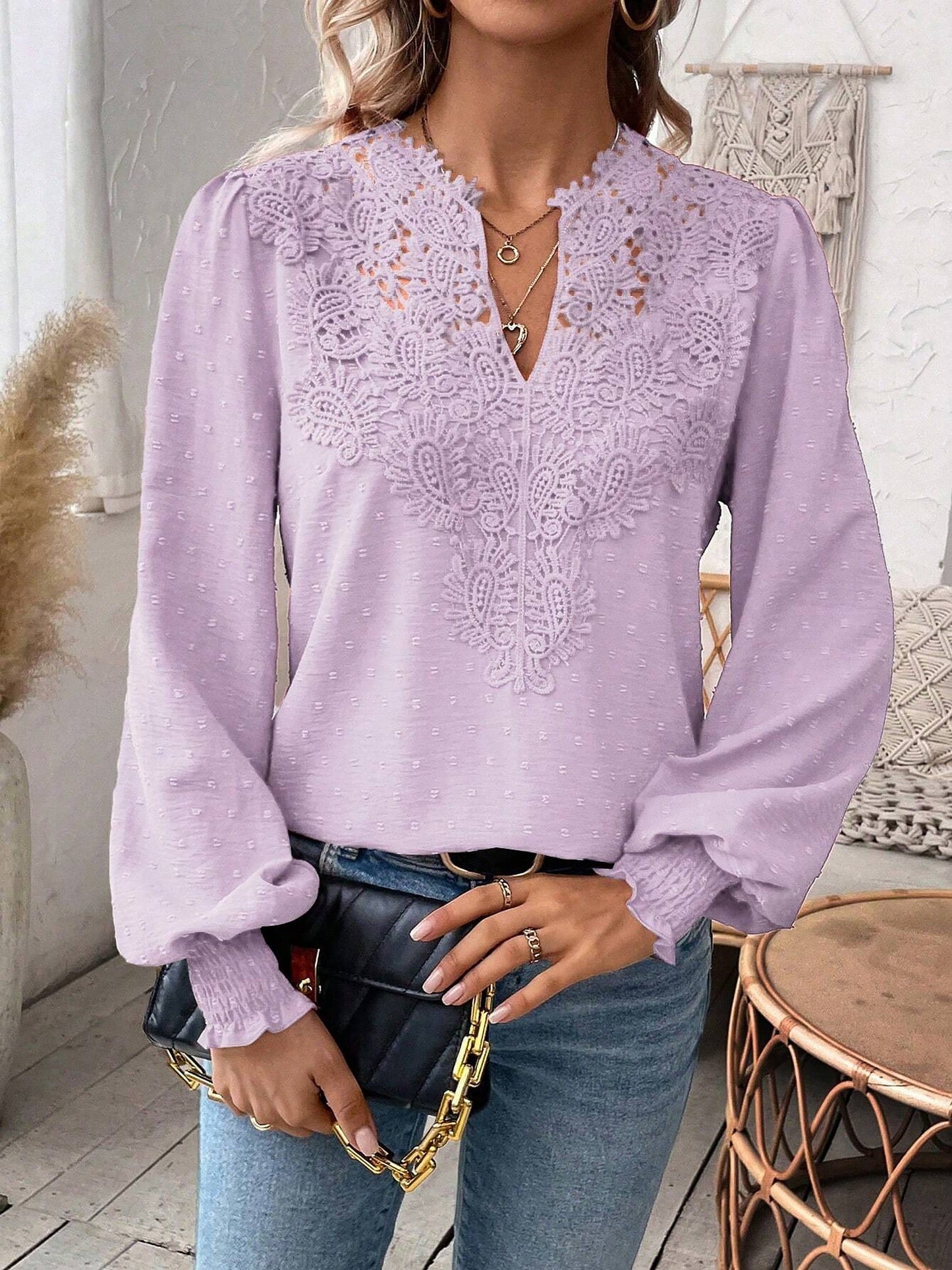 Lavender - Women's dusty rose long-sleeve blouse featuring a lace V-neckline, textured Swiss dot fabric, and smocked cuffs, styled with blue jeans.