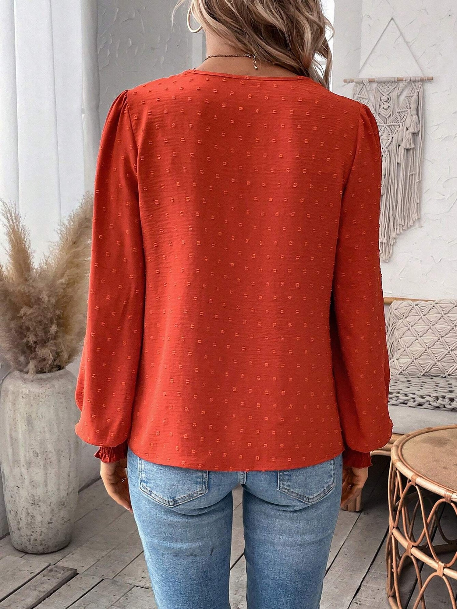 Red - Women's dusty rose long-sleeve blouse featuring a lace V-neckline, textured Swiss dot fabric, and smocked cuffs, styled with blue jeans.