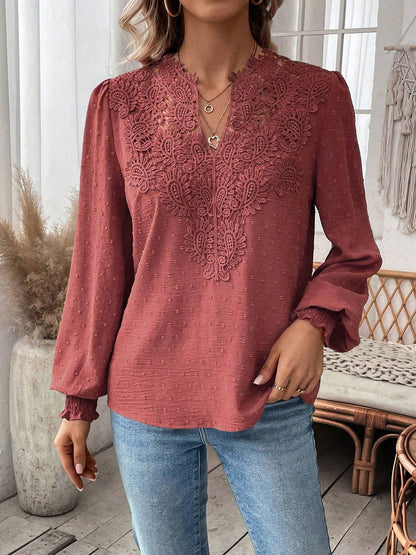 Watermelon Red - Women's dusty rose long-sleeve blouse featuring a lace V-neckline, textured Swiss dot fabric, and smocked cuffs, styled with blue jeans.