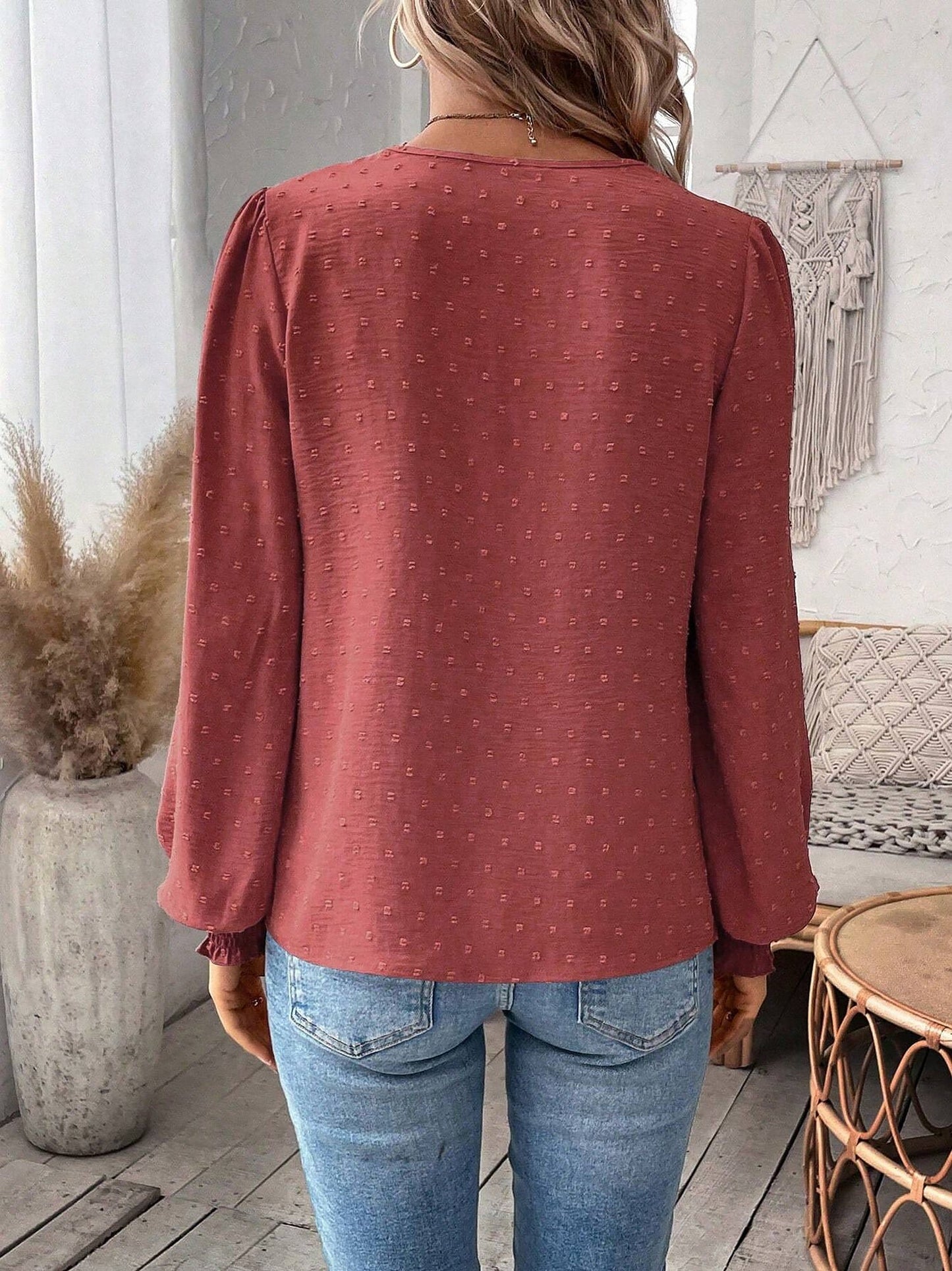 Watermelon Red - Women's dusty rose long-sleeve blouse featuring a lace V-neckline, textured Swiss dot fabric, and smocked cuffs, styled with blue jeans.