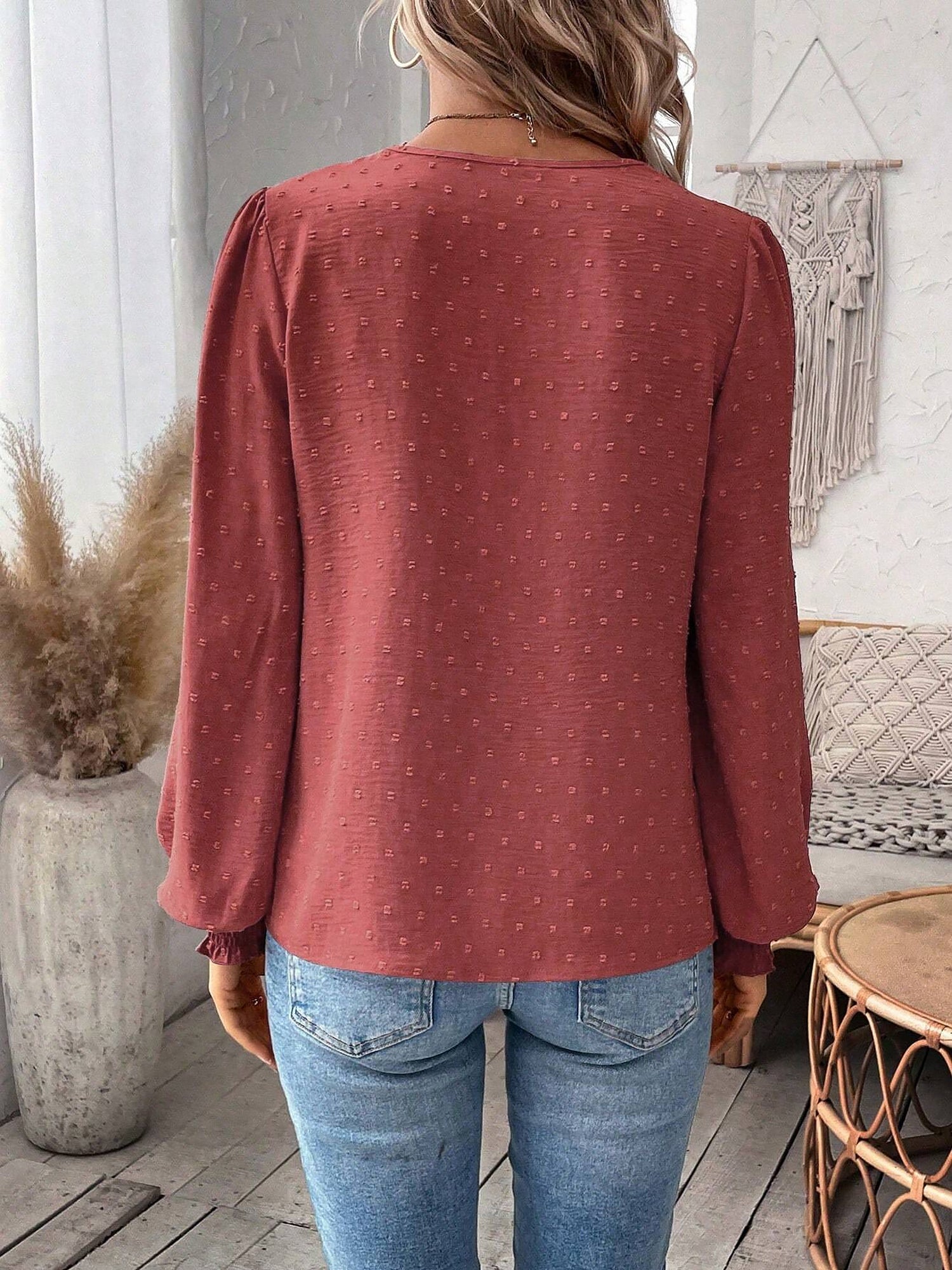 Watermelon Red - Women's dusty rose long-sleeve blouse featuring a lace V-neckline, textured Swiss dot fabric, and smocked cuffs, styled with blue jeans.