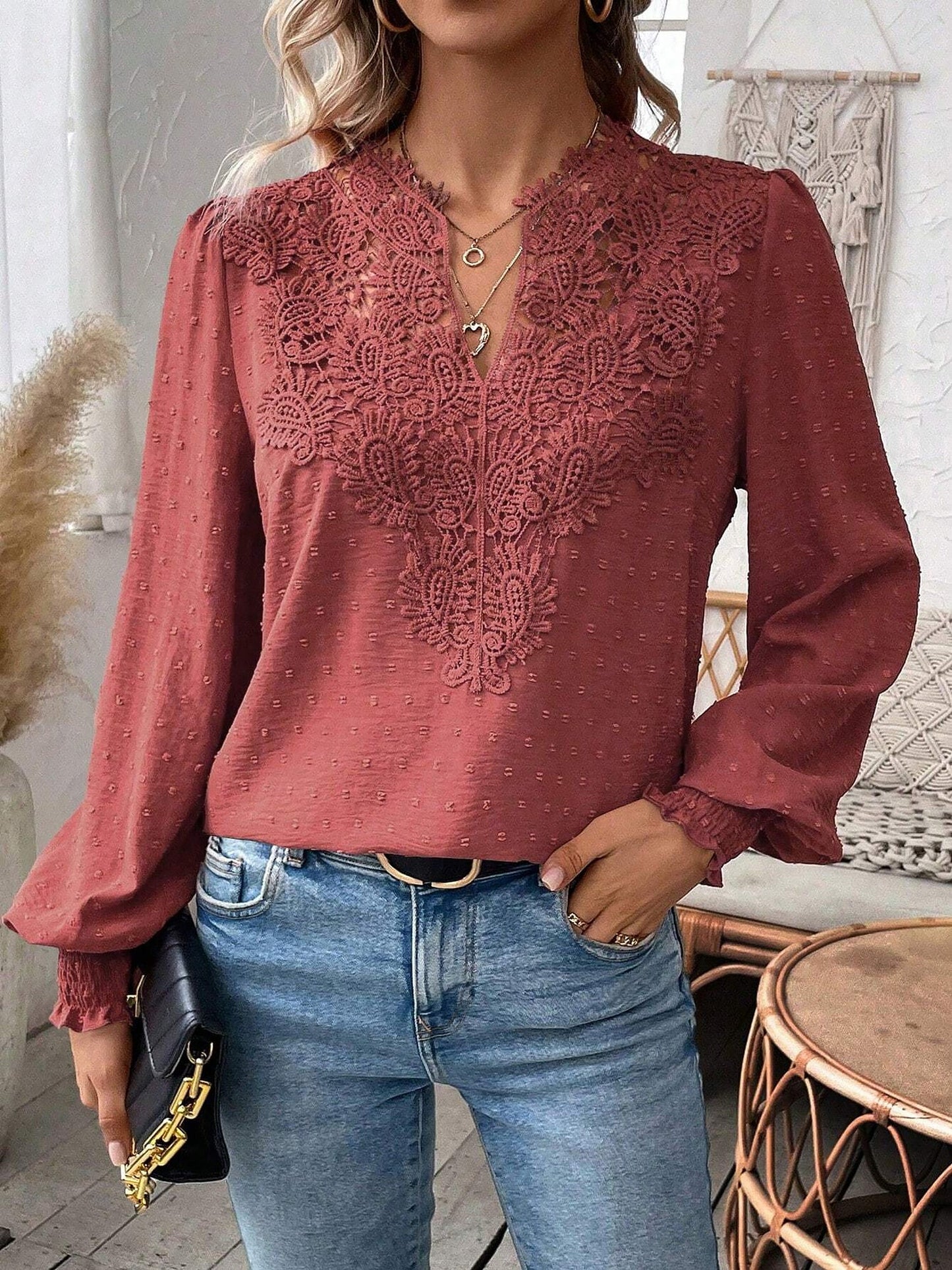 Watermelon Red - Women's dusty rose long-sleeve blouse featuring a lace V-neckline, textured Swiss dot fabric, and smocked cuffs, styled with blue jeans.