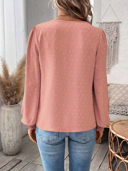 Pink - Women's dusty rose long-sleeve blouse featuring a lace V-neckline, textured Swiss dot fabric, and smocked cuffs, styled with blue jeans.