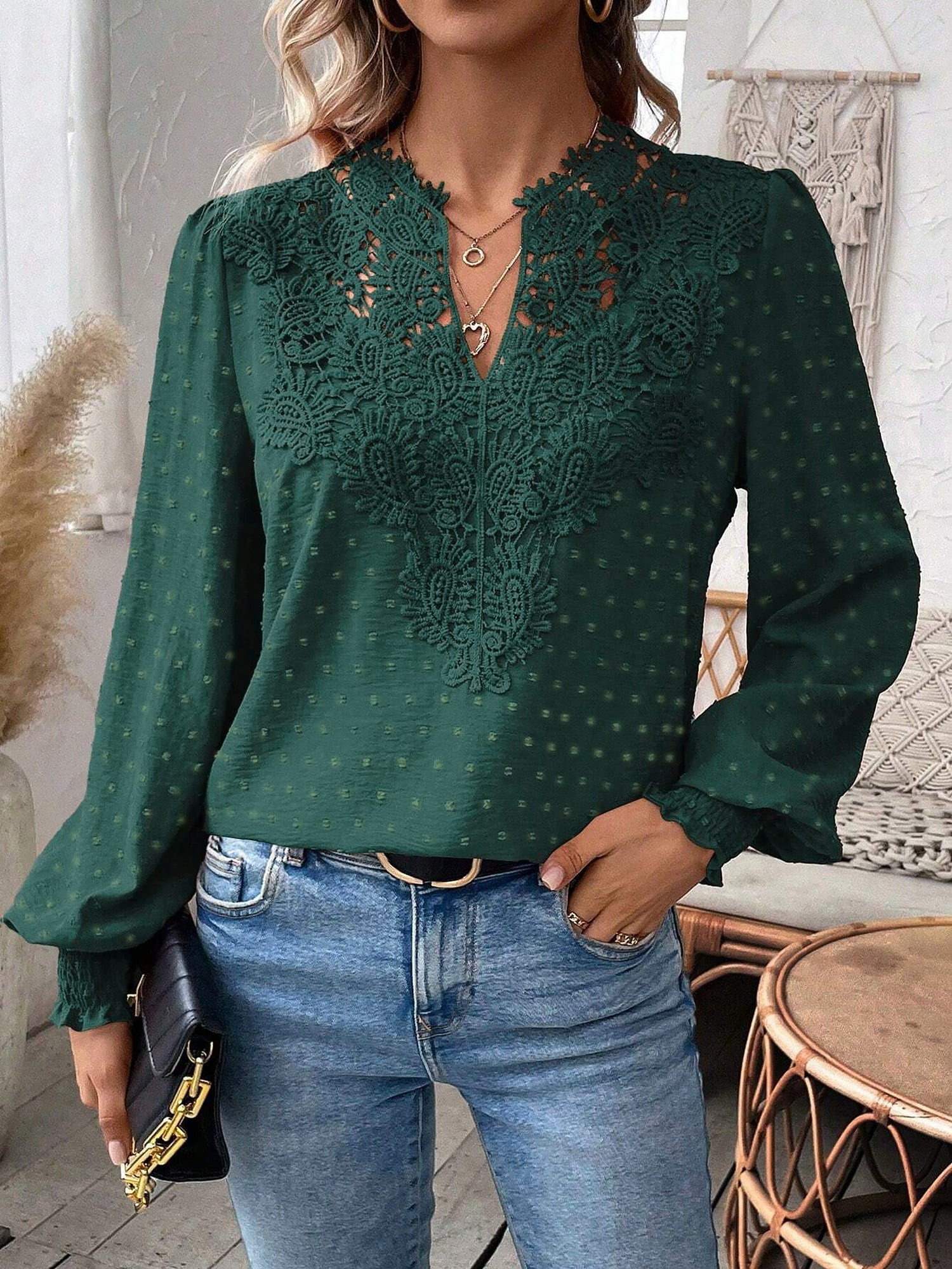 Green - Women's dusty rose long-sleeve blouse featuring a lace V-neckline, textured Swiss dot fabric, and smocked cuffs, styled with blue jeans.