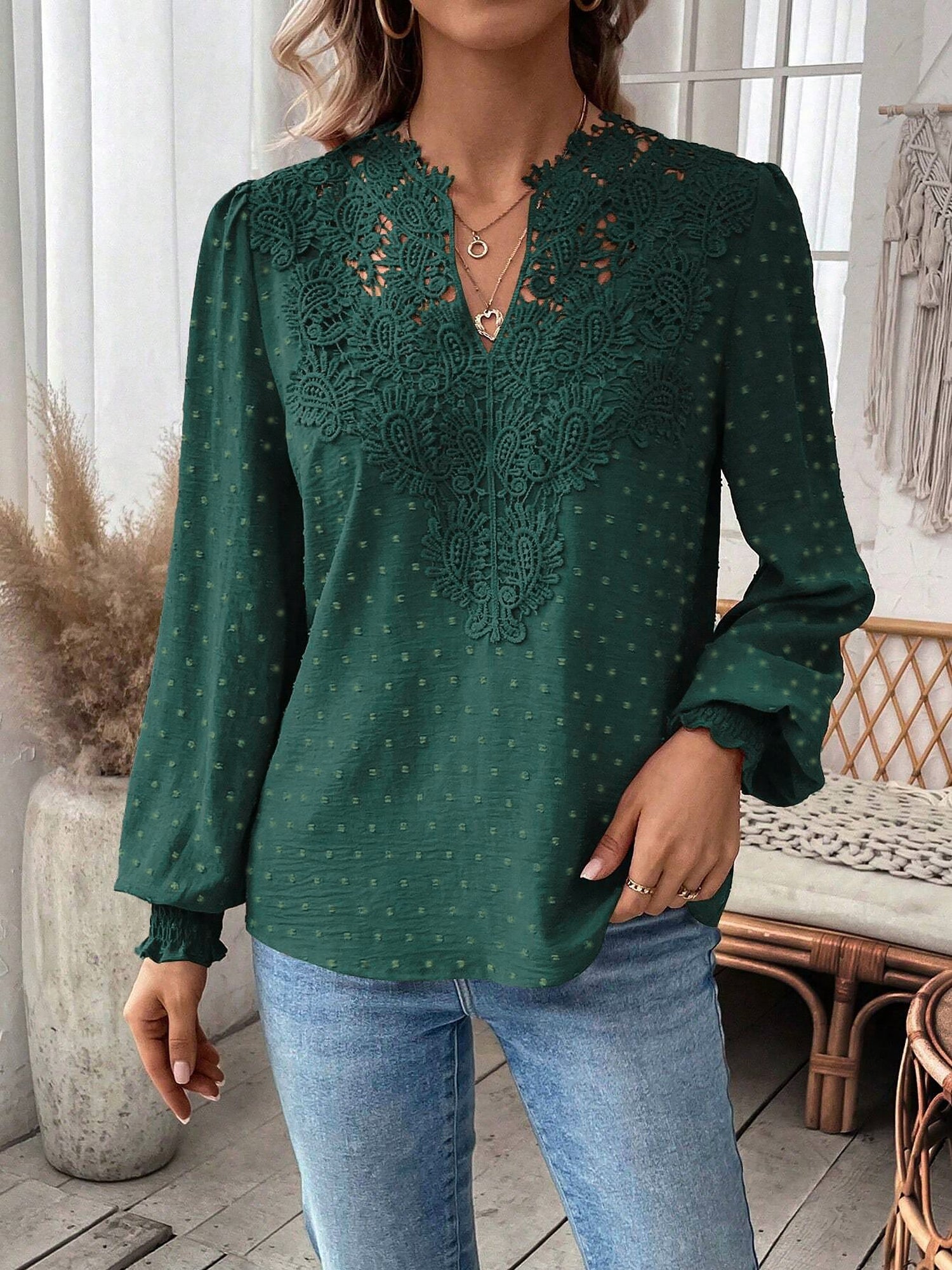 Green - Women's dusty rose long-sleeve blouse featuring a lace V-neckline, textured Swiss dot fabric, and smocked cuffs, styled with blue jeans.