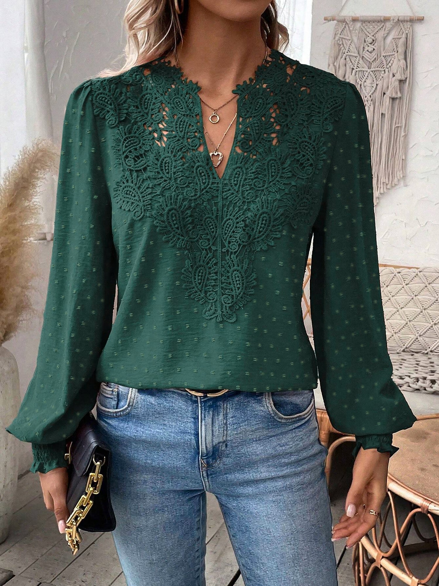 Green - Women's dusty rose long-sleeve blouse featuring a lace V-neckline, textured Swiss dot fabric, and smocked cuffs, styled with blue jeans.