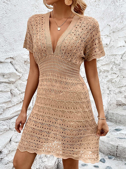 Khaki - A woman wears a white, short-sleeve mini cover-up featuring a deep V-neck, a wide smocked waist, and an all-over geometric open-knit pattern.
