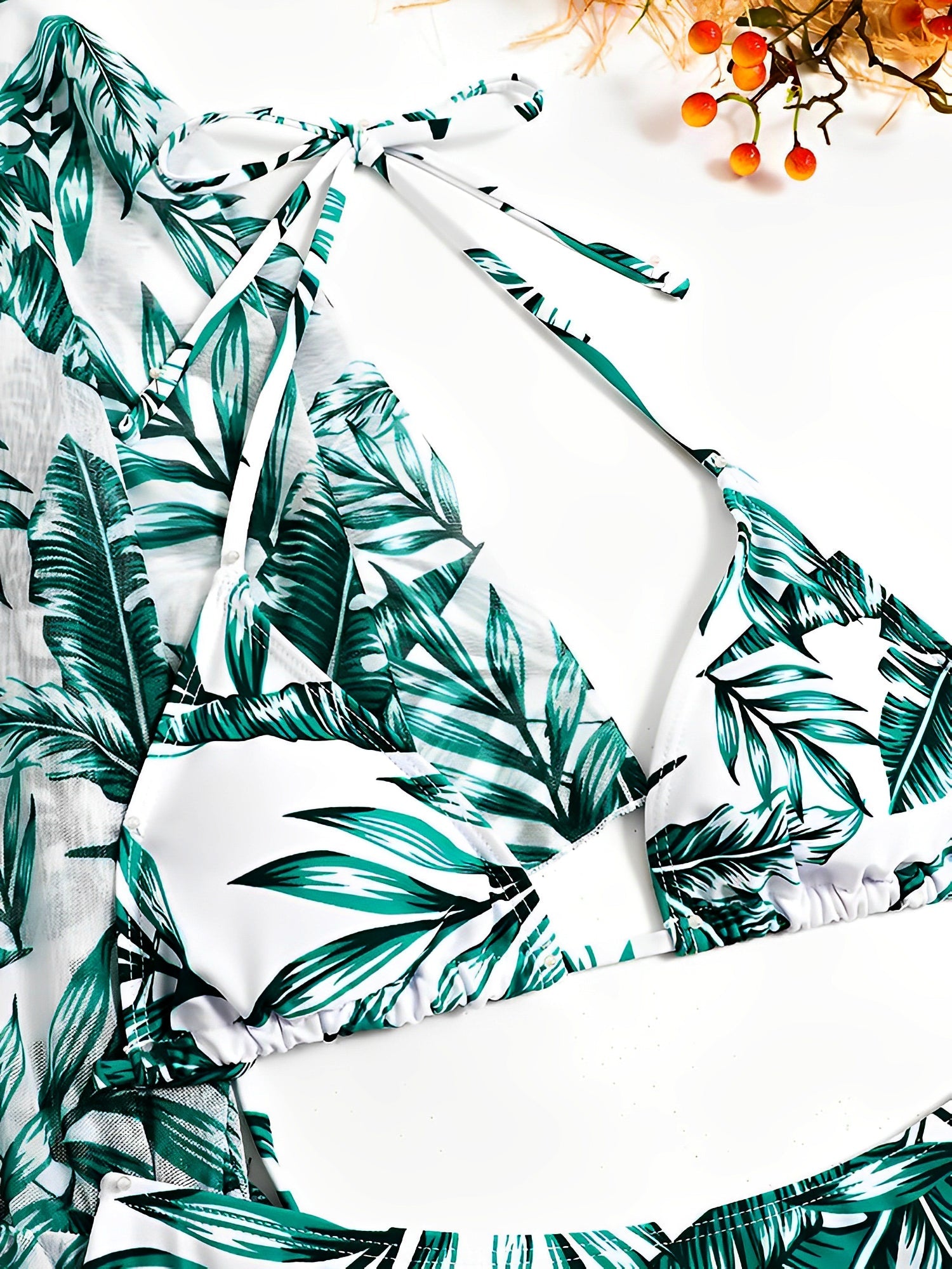 Green - A woman models a sheer, short-sleeve mini cover-up with a vibrant tropical leaf print in shades of purple, blue, and pink, featuring a deep V-neck, drawstring waist, and ruched sides with ties.