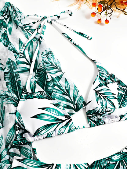 Green - A woman models a sheer, short-sleeve mini cover-up with a vibrant tropical leaf print in shades of purple, blue, and pink, featuring a deep V-neck, drawstring waist, and ruched sides with ties.