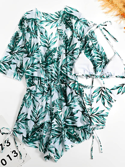 Green - A woman models a sheer, short-sleeve mini cover-up with a vibrant tropical leaf print in shades of purple, blue, and pink, featuring a deep V-neck, drawstring waist, and ruched sides with ties.