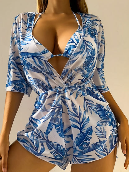 Blue - A woman models a sheer, short-sleeve mini cover-up with a vibrant tropical leaf print in shades of purple, blue, and pink, featuring a deep V-neck, drawstring waist, and ruched sides with ties.
